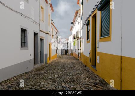 Ruelle pavée entre murs blanchis à la chaux de maisons aux accents de couleur et buanderie se délaquant sur les lignes dans le quartier traditionnel Banque D'Images