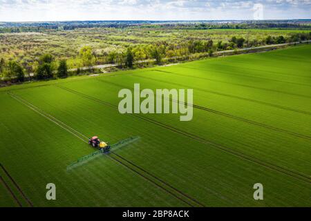 Terres agricoles en Europe, tracteur pulvérisant des pesticides dans les champs verts Banque D'Images