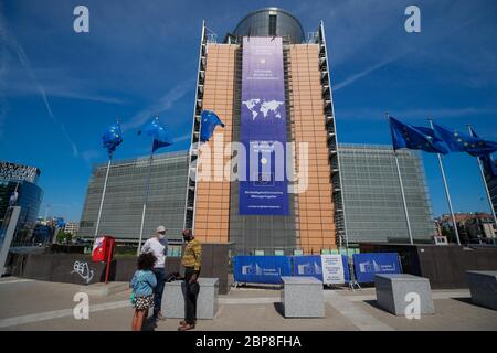 Bruxelles, Belgique. 18 mai 2020. Les personnes portant un masque facial sont vues devant le siège de la Commission européenne à Bruxelles, Belgique, le 18 mai 2020. La Belgique est entrée lundi dans la phase 2 de la déconditionnement, les écoles ouvrant leurs cours à certains grades dans des conditions organisationnelles strictes. Crédit: Zhang Cheng/Xinhua/Alay Live News Banque D'Images