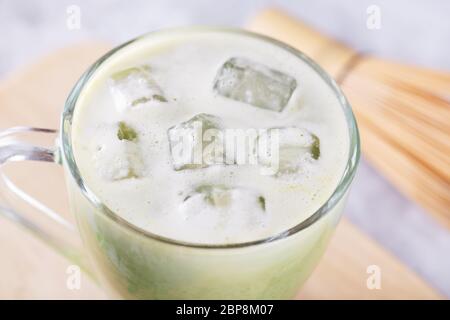 Gros plan d'un morceau de glace dans un verre avec du lait de matcha frais, du thé vert avec du lait Banque D'Images
