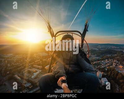 Powered parachute tandem, l'homme en tenant l'appareil photo d'action avec des selfies Banque D'Images