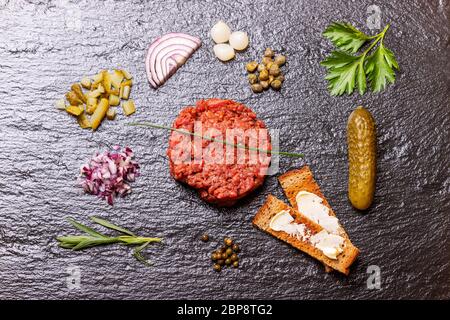 Matières steak tartare sur l'ardoise noire Banque D'Images