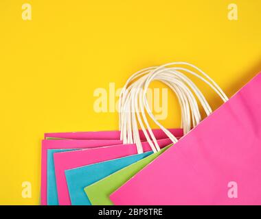 Multi-couleur rectangulaire des sacs en papier avec poignées blanc sur fond jaune, télévision lay Banque D'Images