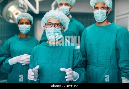 Équipe de chirurgiens dans la salle d'opération se préparant à la chirurgie Banque D'Images