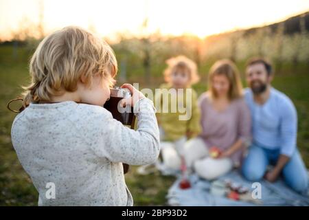 Petit garçon avec appareil photo prendre une photo sur un pique-nique familial en plein air dans la nature. Banque D'Images