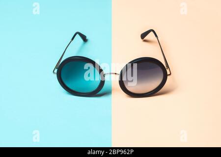 Photo de mode, lunettes de soleil rondes sur fond bleu pastel et corail. Concept d'été minimal. Banque D'Images