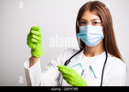 Médecin en clinique tenant des tubes à essai avec le vaccin. Banque D'Images