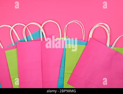 Multi-couleur rectangulaire des sacs en papier avec poignées blanches sur fond rose, télévision lay Banque D'Images