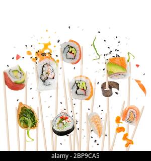 Rouleaux de sushi et d'ingrédients avec des baguettes isolé sur fond blanc Banque D'Images