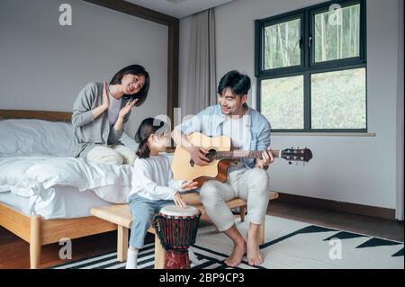 Maman et papa et fille chantent à la maison Banque D'Images