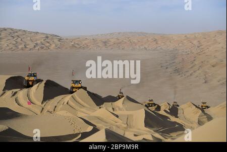 (200518) -- YULI, 18 mai 2020 (Xinhua) -- les travailleurs conduisent des bulldozers sur le site de construction d'une autoroute dans le désert de Taklimakan, dans la région autonome du Xinjiang, dans le nord-ouest de la Chine, le 16 mai 2020. La construction de l'autoroute Yuli-Qiemo, la troisième route nord-sud traversant le désert de Taklimakan, est entrée dans la ruée finale. Les travailleurs de China Communications Construction Company Ltd. Travaillent sur la plus grande dune de ce projet, avec un volume estimé de 1.2 millions de mètres cubes de sable à traiter. Ils ont établi des camps à côté de la dune pour la commodité du travail et reçoivent le nece quotidien Banque D'Images