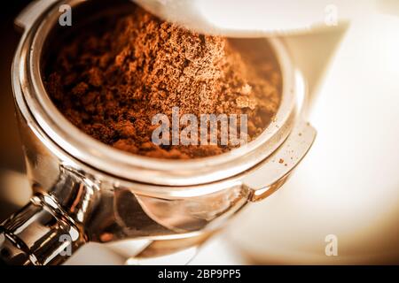 Grains de café frais en cours de préparation pour une tasse d'espresso fort. Banque D'Images