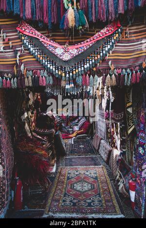 Entrée de magasin de tapis de bazar turc décorée avec divers tapis faits à la main avec des pompons colorés. Banque D'Images