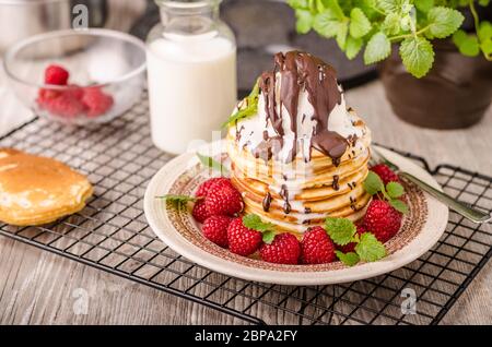 Crêpes américaines avec glace et chocolat, herbes et baies autour Banque D'Images