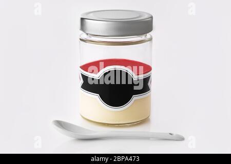 Dessert lactée à la crème et gelée fruitée dans un pot isolé sur fond blanc. Banque D'Images