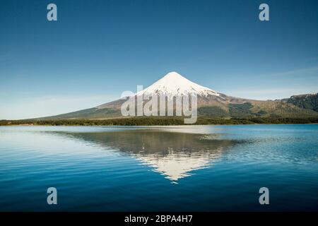 Le volcan Osorno enneigé se reflète dans les eaux calmes du Lago Todos Los Santos, près de Puerto Varas, région de Los Lagos, Chili Banque D'Images