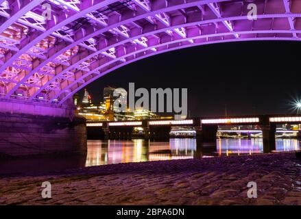 Southwark Bridge la nuit depuis le bas montrant un nouvel éclairage, un pavage ancien et Cannon Street Bridge en arrière-plan. Banque D'Images