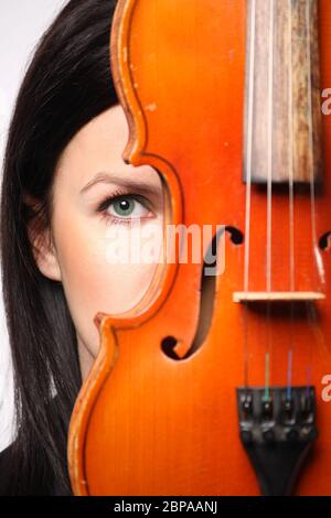 Belle lettone russe Europe orientale fille derrière le violon fond blanc yeux verts style traditionnel studio musique amant look étonnant Banque D'Images