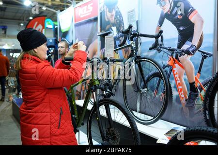 Femme prenant la photo d'une étiquette avec les caractéristiques techniques des vélos présentés sur un stand. Expo vélo 2019. 8 mars 2019. Kiev, Ukraine Banque D'Images