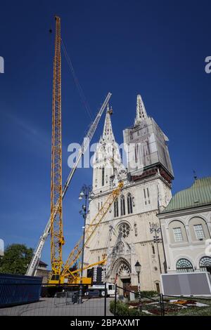 Zagreb, Croatie - 15 avril 2020 : les travailleurs avec de grandes grues se préparent à séparer le sommet de la tour de la cathédrale de Zagreb qui a été endommagée par le terq Banque D'Images