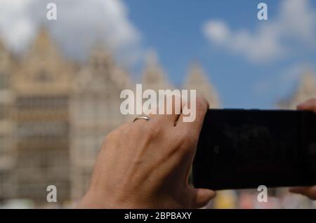 Anvers, Flandre, Belgique. Août 2019. Sur la place de l'hôtel de ville, un smartphone entoure les magnifiques bâtiments de la Renaissance : l'affichage est noir et Banque D'Images