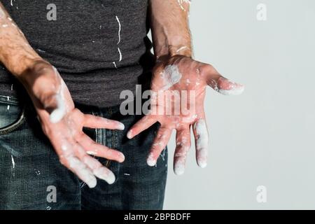 Artisan avec des particules de peinture blanche aux mains et aux vêtements après le travail de peinture rénovation sale travail de formation profession d'enseignement faites-le vous-même Banque D'Images