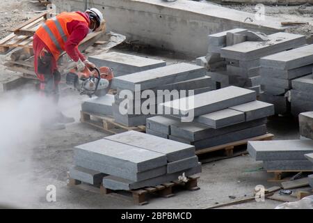 Belgrade, Serbie - 18 mai 2020 : ouvrier de la construction coupant des blocs de pavage avec fraise à disque pour pierre à essence, vue à angle élevé Banque D'Images