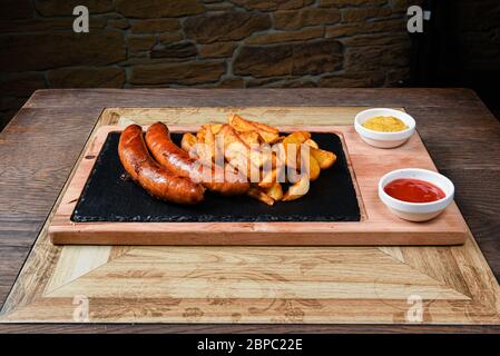 assiette de restaurant servie avec des saucisses et des pommes de terre Banque D'Images