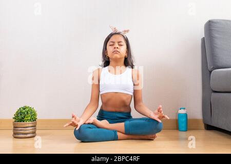 Jeune fille faisant du yoga à la maison Banque D'Images