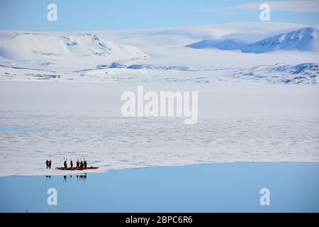 Les touristes qui font une croisière d'expédition participent à une excursion en kayak dans une baie abritée de Svalbard, dans l'Arctique norvégien, en été. Banque D'Images