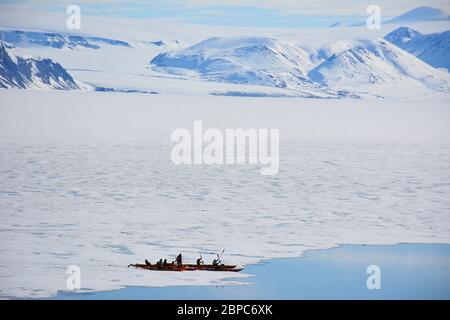 Les touristes qui font une croisière d'expédition participent à une excursion en kayak dans une baie abritée de Svalbard, dans l'Arctique norvégien, en été. Banque D'Images