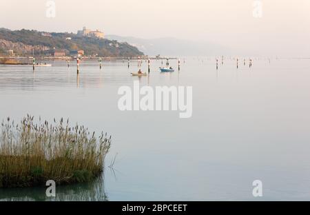 Mer Adriatique du nord sur la côte près de Trieste, Italie, dans un après-midi de novembre brumeux, avec le château de Duino en arrière-plan Banque D'Images