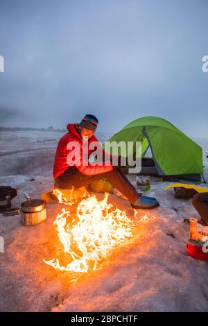 Mountaineer aime les feux de camp tout en campant sur un glacier, l'île de Baffin Banque D'Images