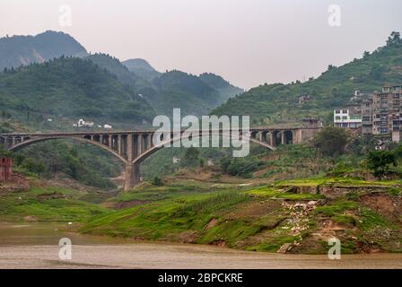 Huangqikou, Chongqing, Chine - 8 mai 2010 : fleuve Yangtze. Pont d'arc double en béton sur le rivage vert devant les collines boisées à la sprint Banque D'Images