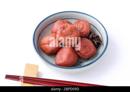 Cuisine japonaise, umeboshi salé dans un plat sur fond blanc Banque D'Images