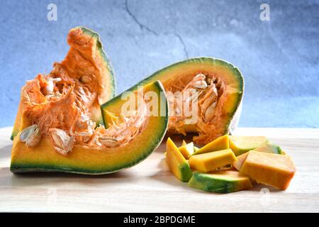 Tranches de citrouille coupées en dés et porridge de citrouille sur un fond en bois sombre. Concept cuisine citrouille hachée. Fond de nourriture. Mise au point sélective. Banque D'Images