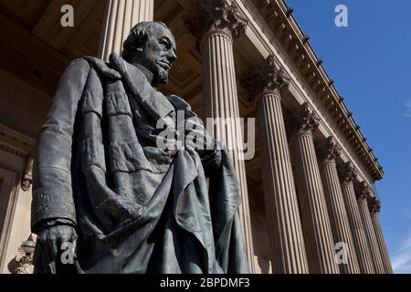 Statue de l'ancien Premier ministre britannique Benjamin Disraeli devant les colonnes corinthiennes de la façade est de la salle St George, Liverpool Banque D'Images