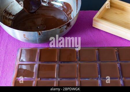 Versez le chocolat chaud dans les moules à bonbons. Le processus de la cuisine maison des bonbons sains sans sucre. Banque D'Images