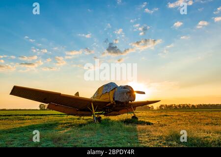 Petit avion jaune au coucher du soleil. Soirée à l'aérodrome Banque D'Images