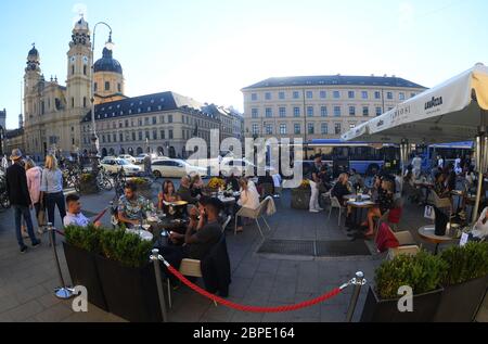 Munich, Allemagne. 18 mai 2020. Les clients du Tambosi s'assoient sur Odeonsplatz, sur fond de Theatinerkirche, dans des températures chaudes et un ciel bleu, et laissent la journée s'éteindre. Credit: Felix Hörhager/dpa/Alay Live News Banque D'Images