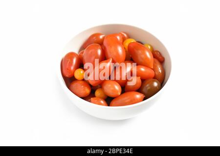 Tomates cerises. Tomates cerises dans un bol en céramique isolé sur fond blanc. Vue de dessus. Mise au point sélective Banque D'Images