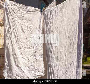 Le linge de lit propre lavé est séché à l'air frais dans le village. Banque D'Images