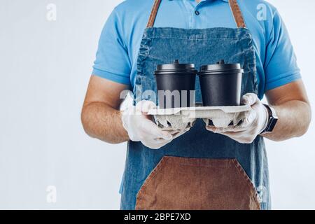 Homme méconnu dans un polo bleu avec des ordres de livraison de nourriture sur fond gris Banque D'Images