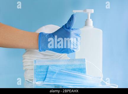 Main du médecin dans des gants bleus montrer le signe de pouce vers le haut. Plusieurs masques médicaux différents, masque chirurgical protecteur jetable.coronavirus virus covid virus Banque D'Images