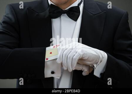 Au milieu de la scène magicien tour de magie avec des cartes à l'arrière-plan gris Banque D'Images