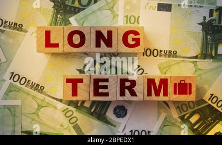 À long terme sur les cubes en bois mis sur de nombreux billets réels de 100 euros. Investissement ou prêt d'affaires concept Banque D'Images