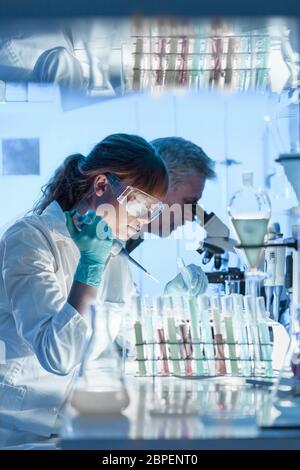 Soins de santé les chercheurs travaillant en laboratoire de sciences de la vie. Jeune femme chercheur scientifique principal et superviseur de la préparation et de l'analyse de microsc Banque D'Images