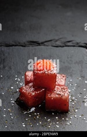 Feux de sashimi de thon dans la sauce de soja avec des oeufs de saumon, l'aneth et le sel épais sur ardoise. Le poisson cru de style traditionnel japonais. Vertical image. Banque D'Images