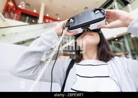 Femme essayant de la réalité virtuelle à museum Banque D'Images