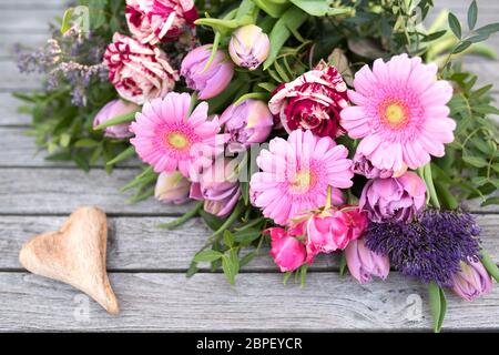 La vie toujours au printemps avec des fleurs et un coeur sur planches vintage gris pour la fête des mères Banque D'Images